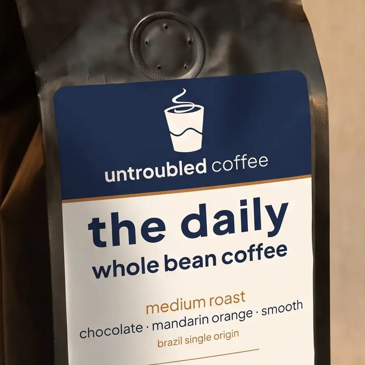 the daily whole bean coffee, black bag with navy and cream label