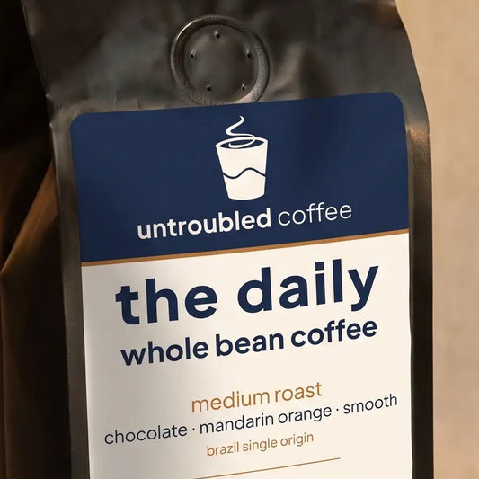 the daily whole bean coffee, black bag with navy and cream label