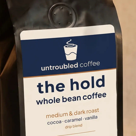 the hold whole bean coffee, black bag with navy and cream label