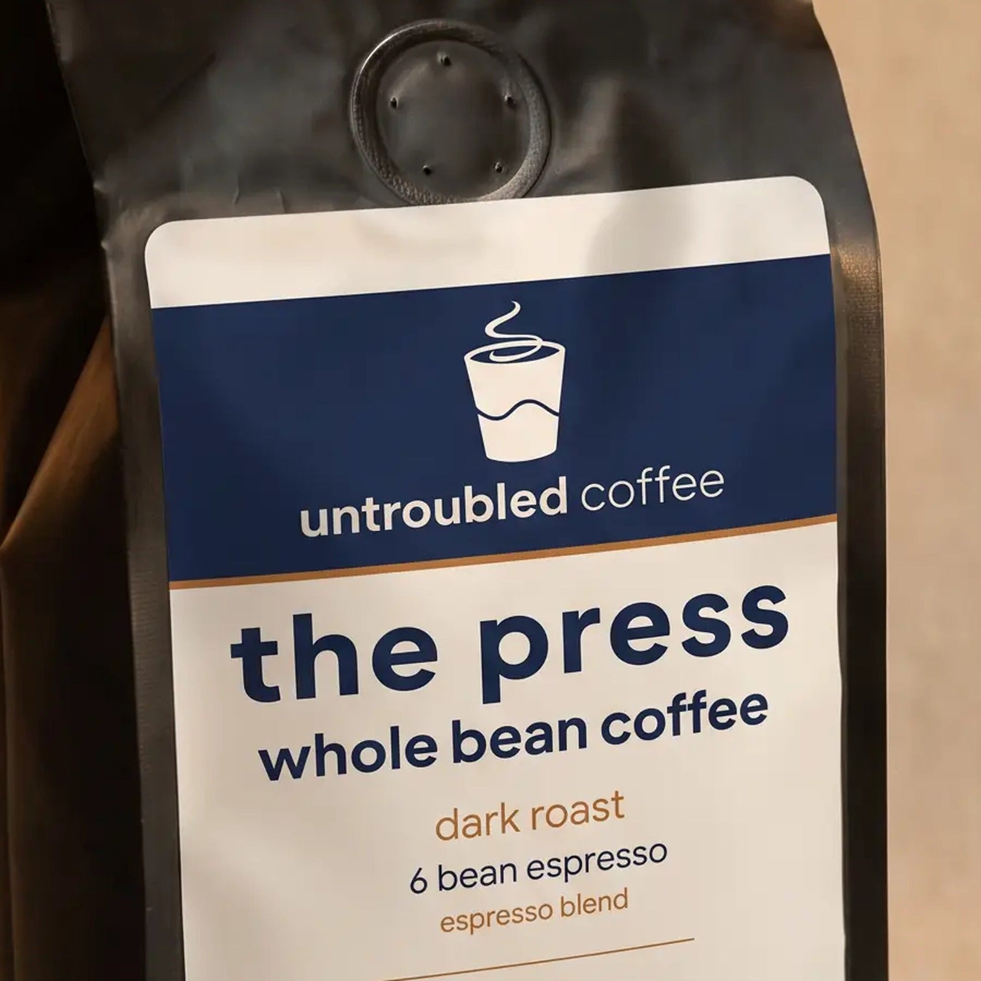 the press whole bean coffee, black bag with navy and cream label